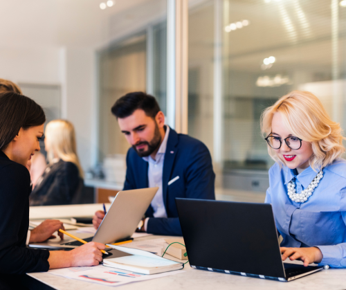 People sitting around a desk working with a deaf person present