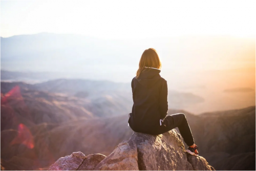 woman sitting on a mountain top