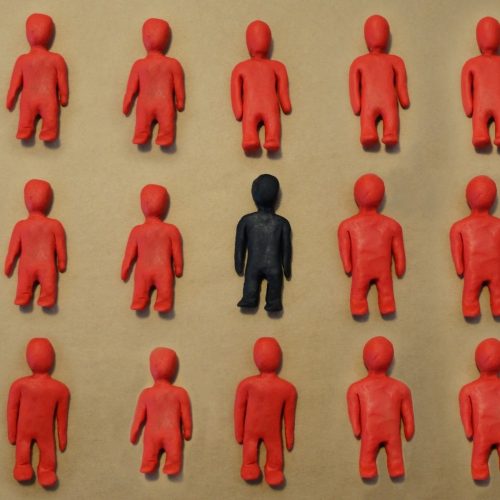 Deaf Identity - one black figurine amongst all red