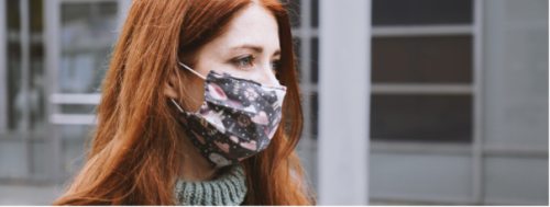 Red headed woman with hearing loss wearing a mask