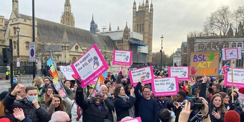 Deaf Protestors outside of Parliament holding banners