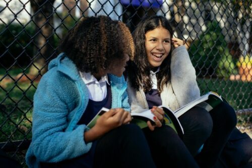 Two students sitting reading a book