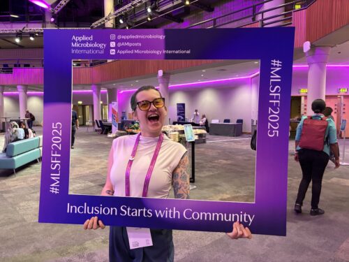 Max holding purple photo frame which says inclusion starts with community.