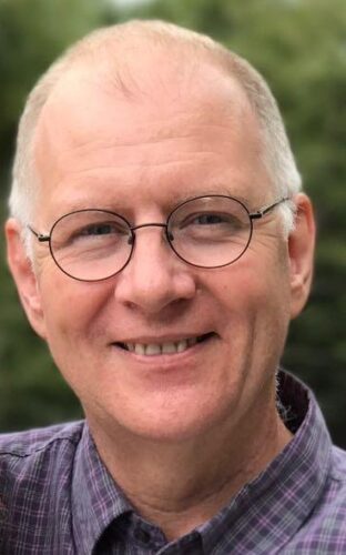 photo of Jeff, man with glasses in front of green background.